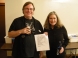 Tom Kohn and Peggi Fournier holding a copy of New Math's set list